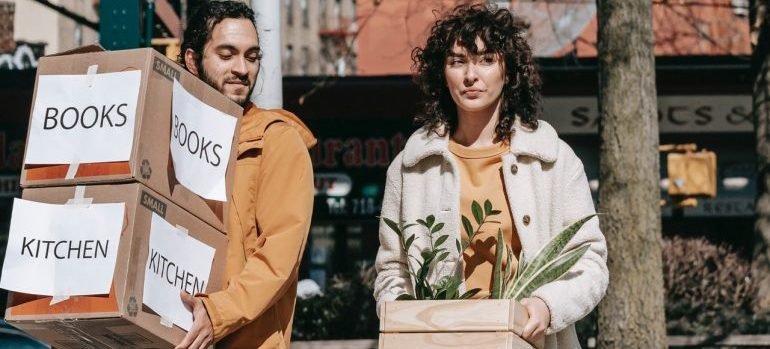 couple carrying boxes on the street