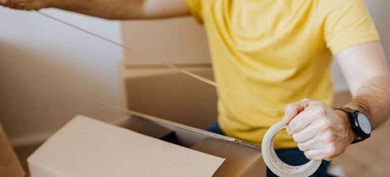 Taping a cardboard box.