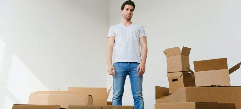 Standing over cardboard boxes for storage.