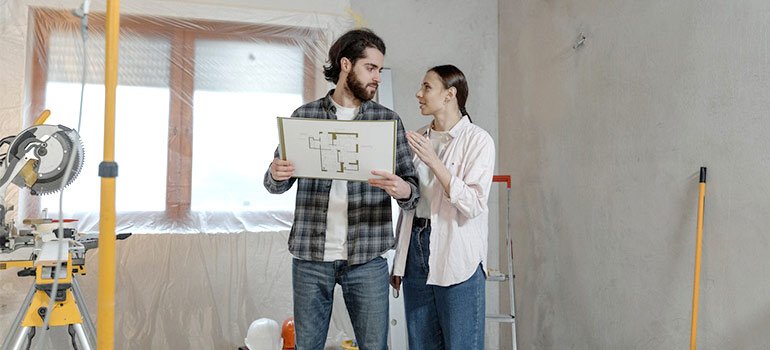 a couple holding a blueprint