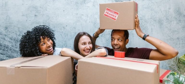 Three people behind cardboard boxes