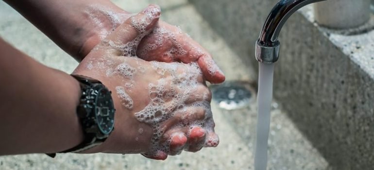 person washing hands, preparing for a safe move during the pandemic