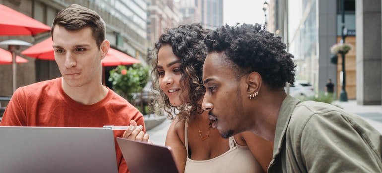 a group of diverse friends does research on the internet to find an apartment in Manhattan