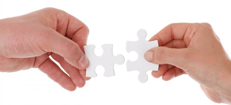 two people holding a puzzle piece each