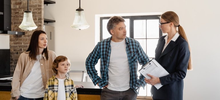A family talking with a moving agent about the difference between local and long-distance move