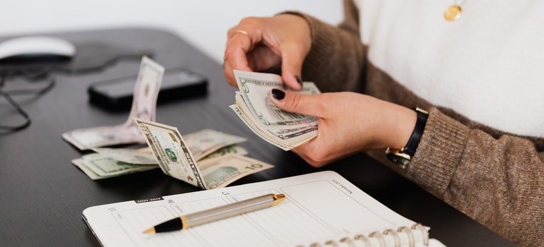 Person counting money to cover the cost to rent a storage unit in NYC