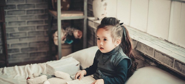 toddler on a bed with a book