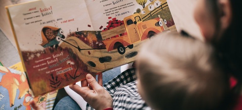 person reading to a toddler while moving with a toddler