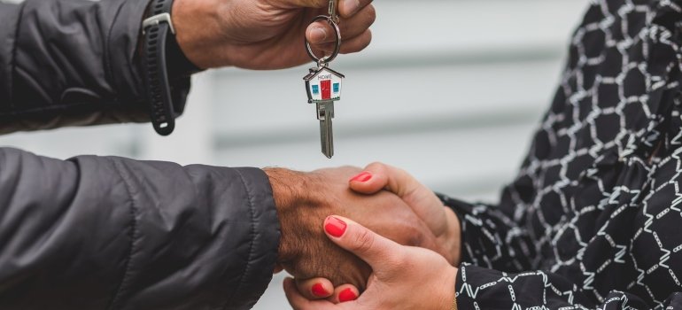 A woman giving keys to a studio apartment to another woman