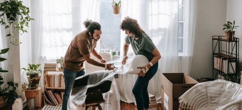 two people using furniture padding when moving