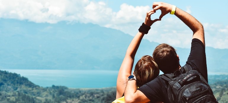 man and woman holding hands making heart
