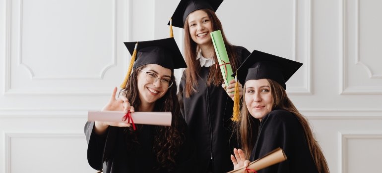 three persons taking a photo after graduating