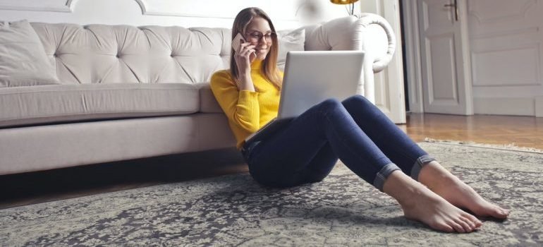 A happy woman sitting on the floor, talking on the phone