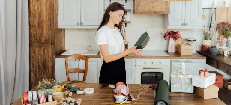A woman using paper and boxes to pack her kitchen appliances
