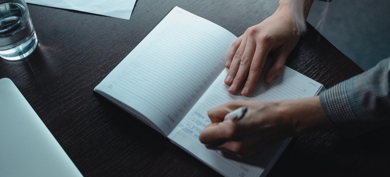 Person writing on a notebook