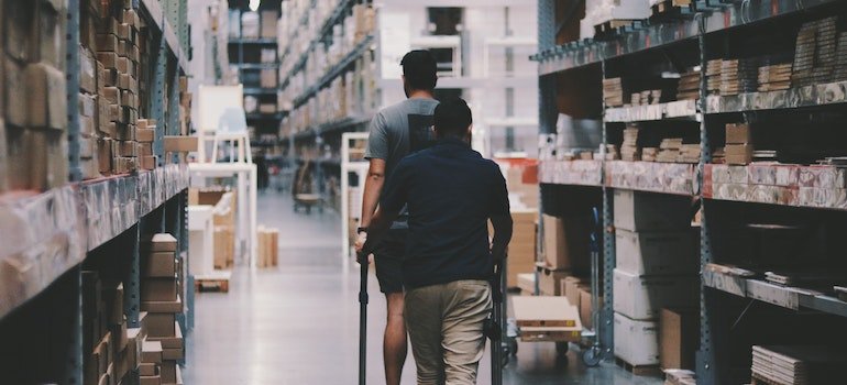 Two man going around a storage;