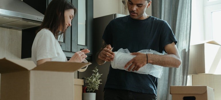 Man and woman packing an item in a box;