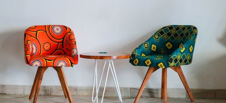 Two colorful chairs with a white wooden table