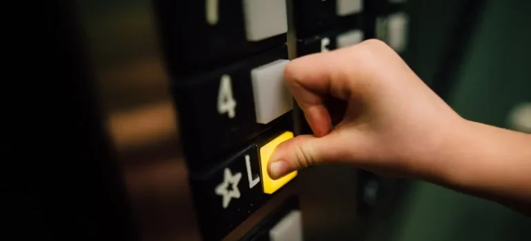 A person pressing the button in an elevator