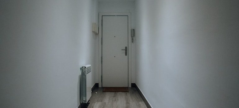 A hallway with a white door at the end of it