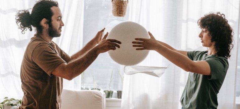 couple unrolling bubble wrap for packing