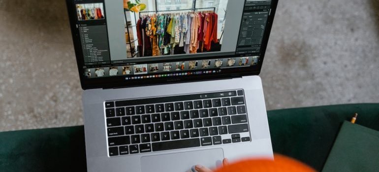 Person in front of the laptop looking at apps to help you sell things before your move in NYC