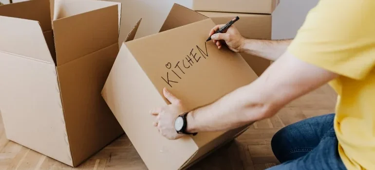 A man writing on a cardboard box