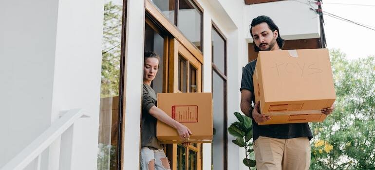 A couple taking boxes out of thier home