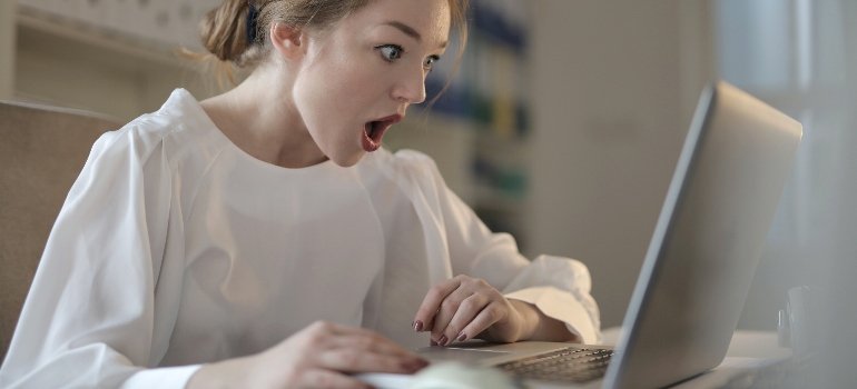 Woman searching for "what to know before moving to Long Island" on laptop