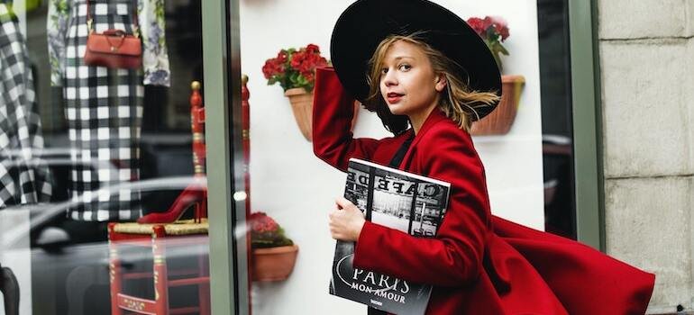 A girl with a stylish hat and red jacket going shopping