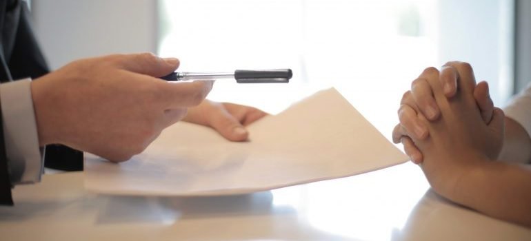 Giving papers and a pen to the other person
