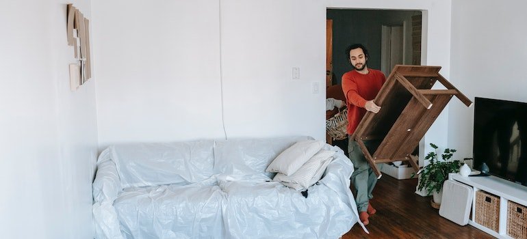 Man carrying a coffee table