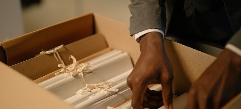 Person Holding a Box of Files