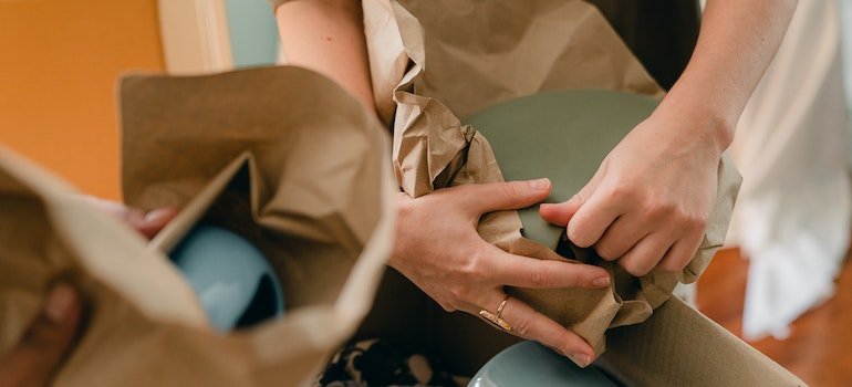 person storing fine china items in parchment