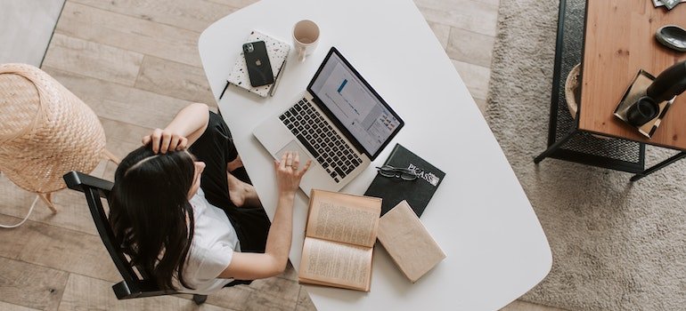 Young woman using laptop at desk in contemporary office