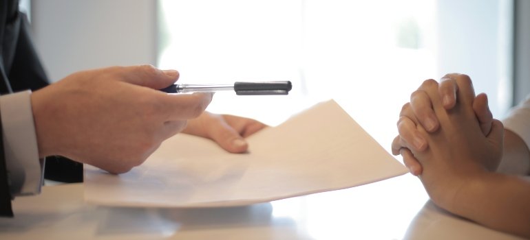 Two people talking about paperwork and deciding on signing it