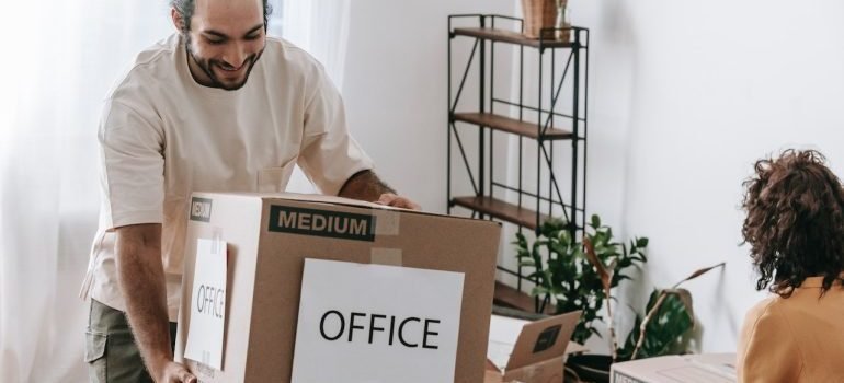 man carrying a box with office stuff