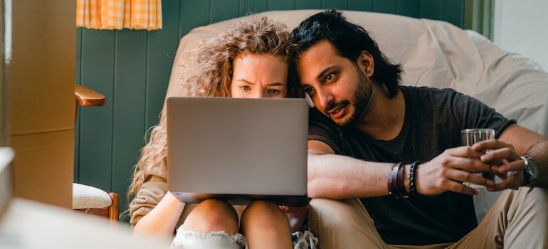 Loving couple using their computer to read the guide about how to make sure your apartment is appraised correctly
