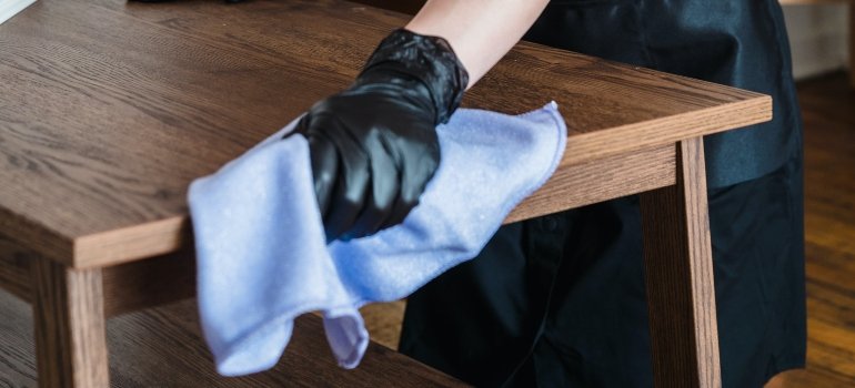 A person cleaning a table before storing it in a unit