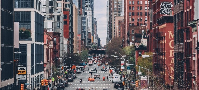 A busy street in New York City with a lot of people and high buildings