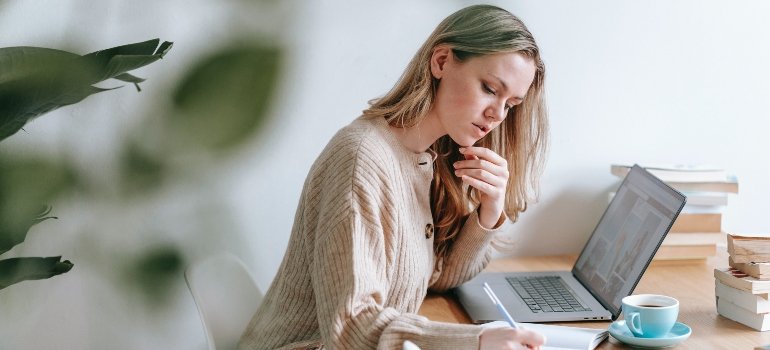 A person doing research on a laptop on how to move to NYC