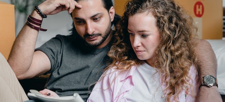 Pensive couple looking through note book.