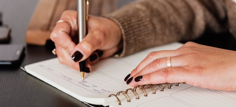 woman writing down notes in diary