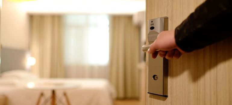 A person holding the door to the room