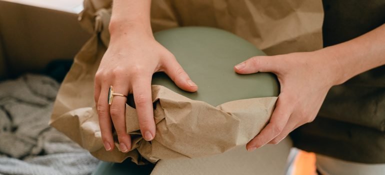 A woman wrapping a plate in a paper