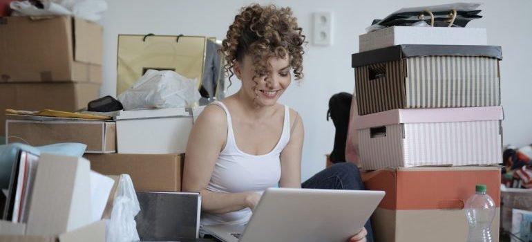 A girl sitting surrounded by boxes