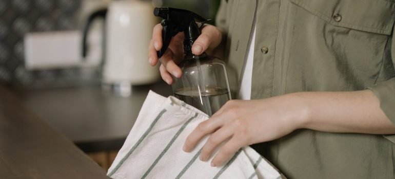 A woman holding cleaning supplies