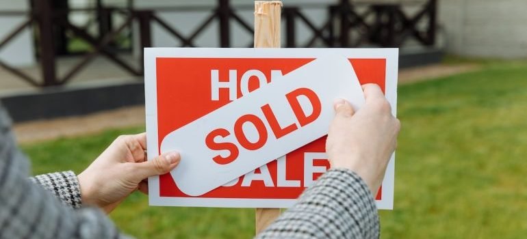 A sign that says sold in front of a house