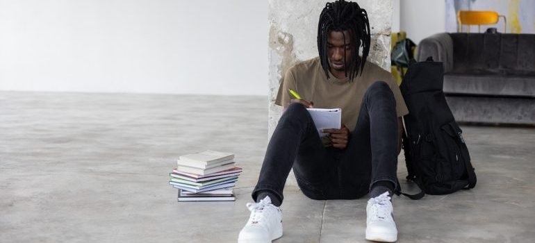 A student writing down all he knows about storing dorm room items