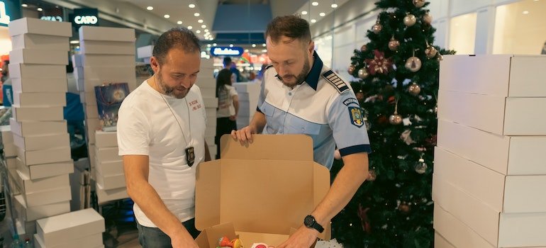 two man packing a box to ensure business continuity when moving offices